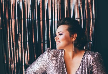 Plussize Outfits: mooie, wat stevigere vrouw met glitterjurk